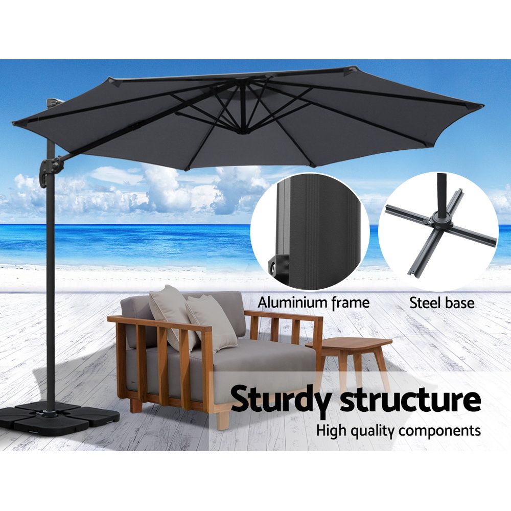 Charcoal cantilever patio umbrella with open canopy and tall pole with square pedestal base