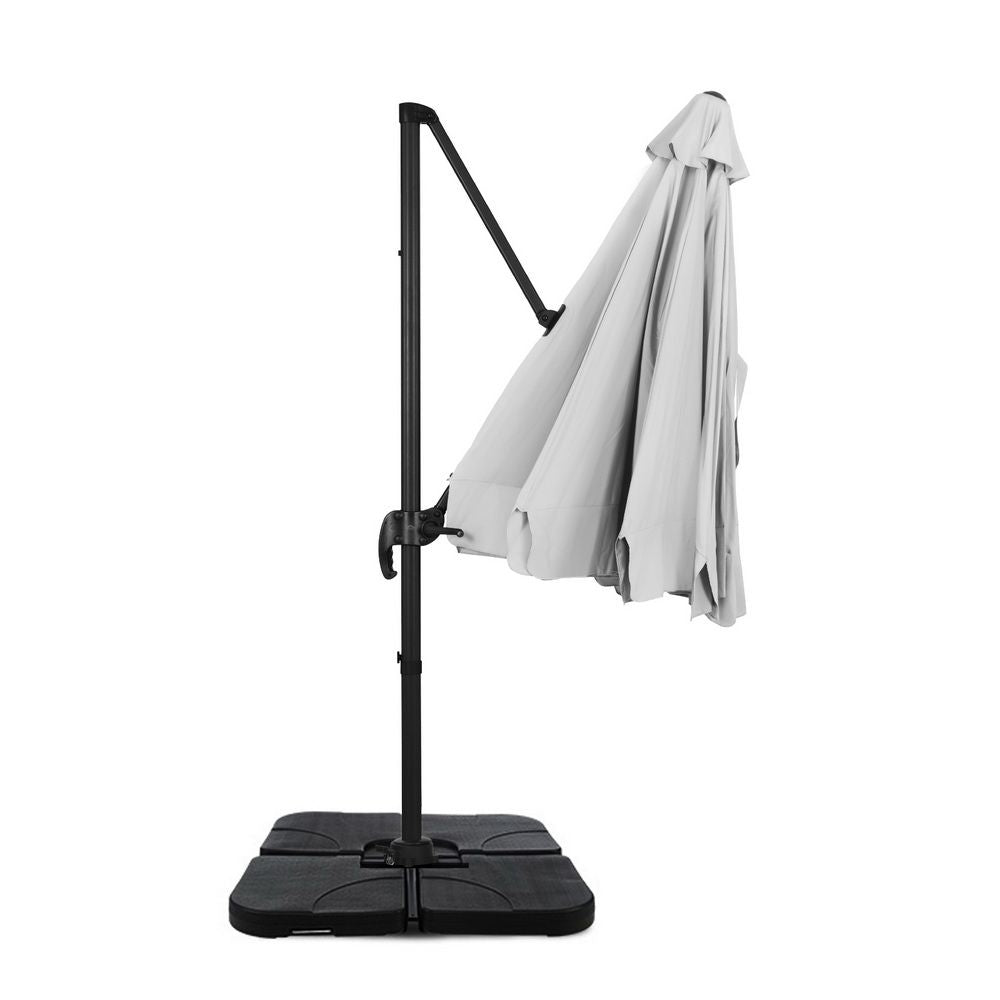 Cantilever patio umbrella with light grey canopy and removable cover hanging