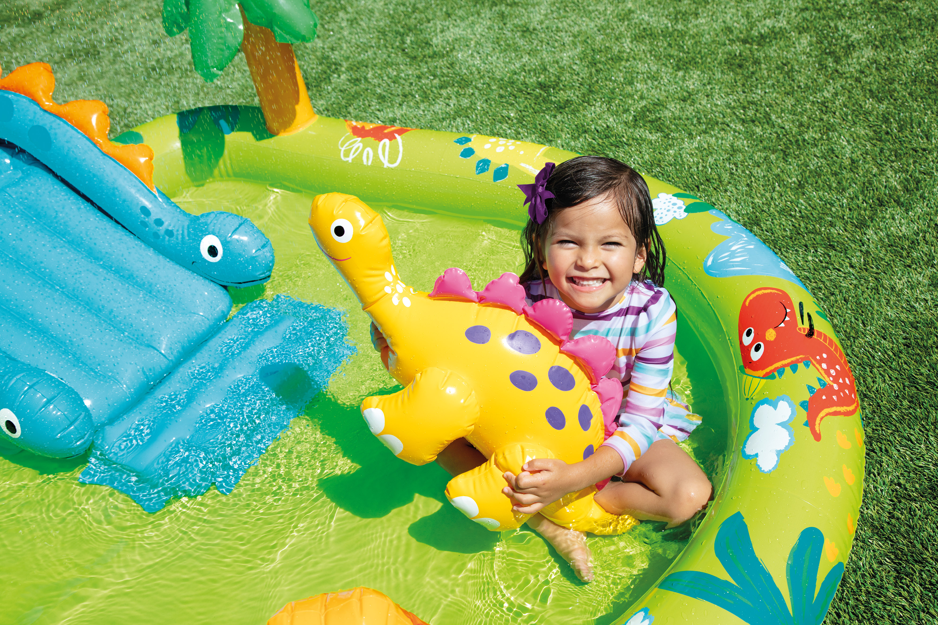 Dinosaur inflatable play centre close-up with child holding a yellow dinosaur