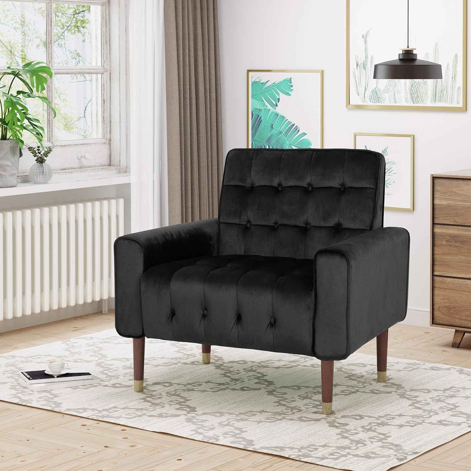 Black tufted velvet armchair with button-tufted back and seat, rounded arms.