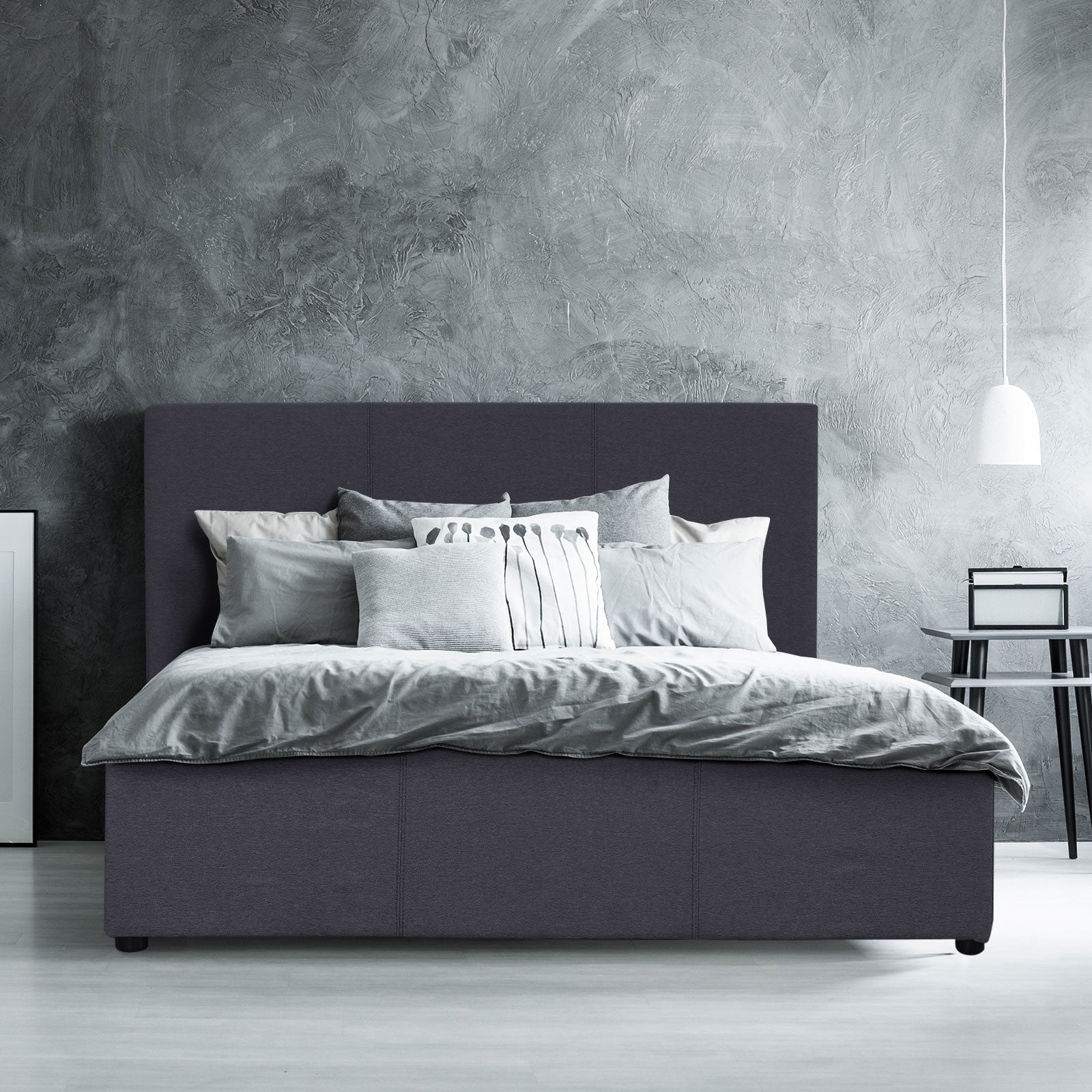 Charcoal double upholstered bed with tall headboard and made-up bedding