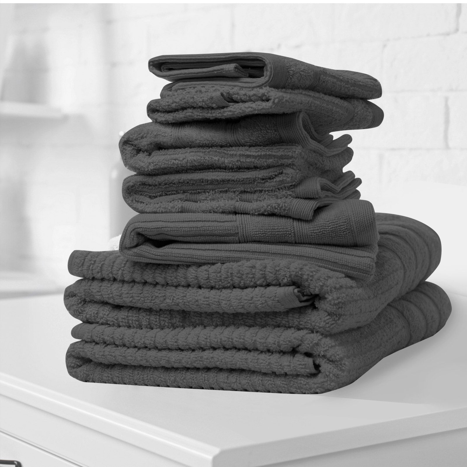 Stack of folded bath towels, dark gray plush terry cloth with textured details