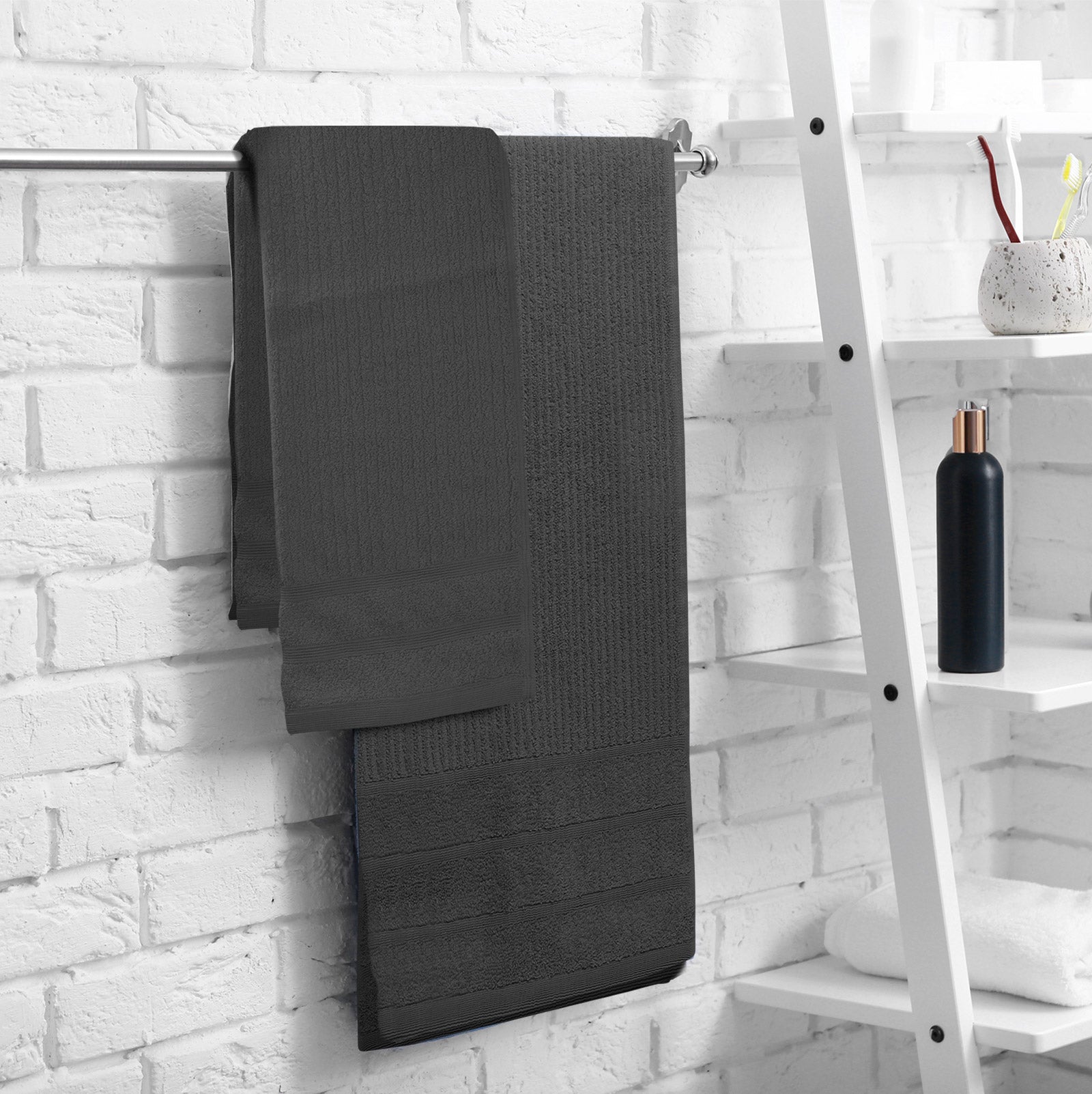 Bath towel set hanging on a rack, dark gray plush terry cloth