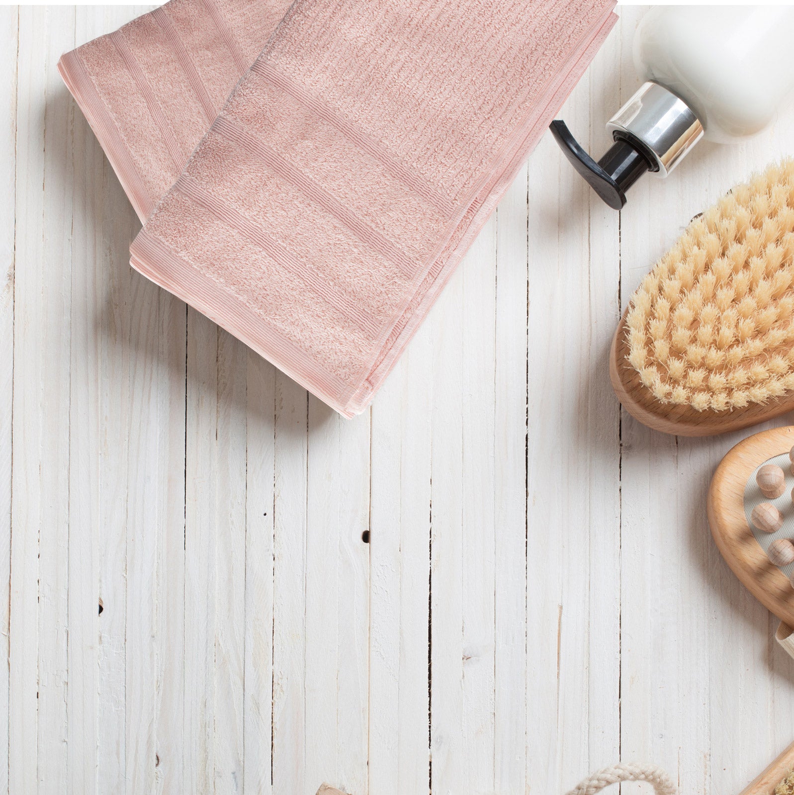 Blush bath towel corner with ribbed pattern, neatly folded flat.