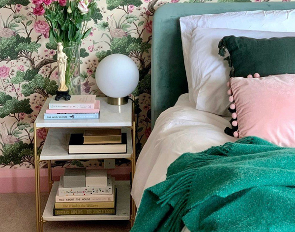 Emerald wool throw blanket draped on bed with soft knit and long fringe