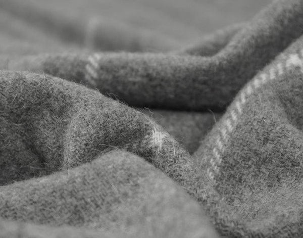 Close-up of grey wool throw fabric with woven striped texture