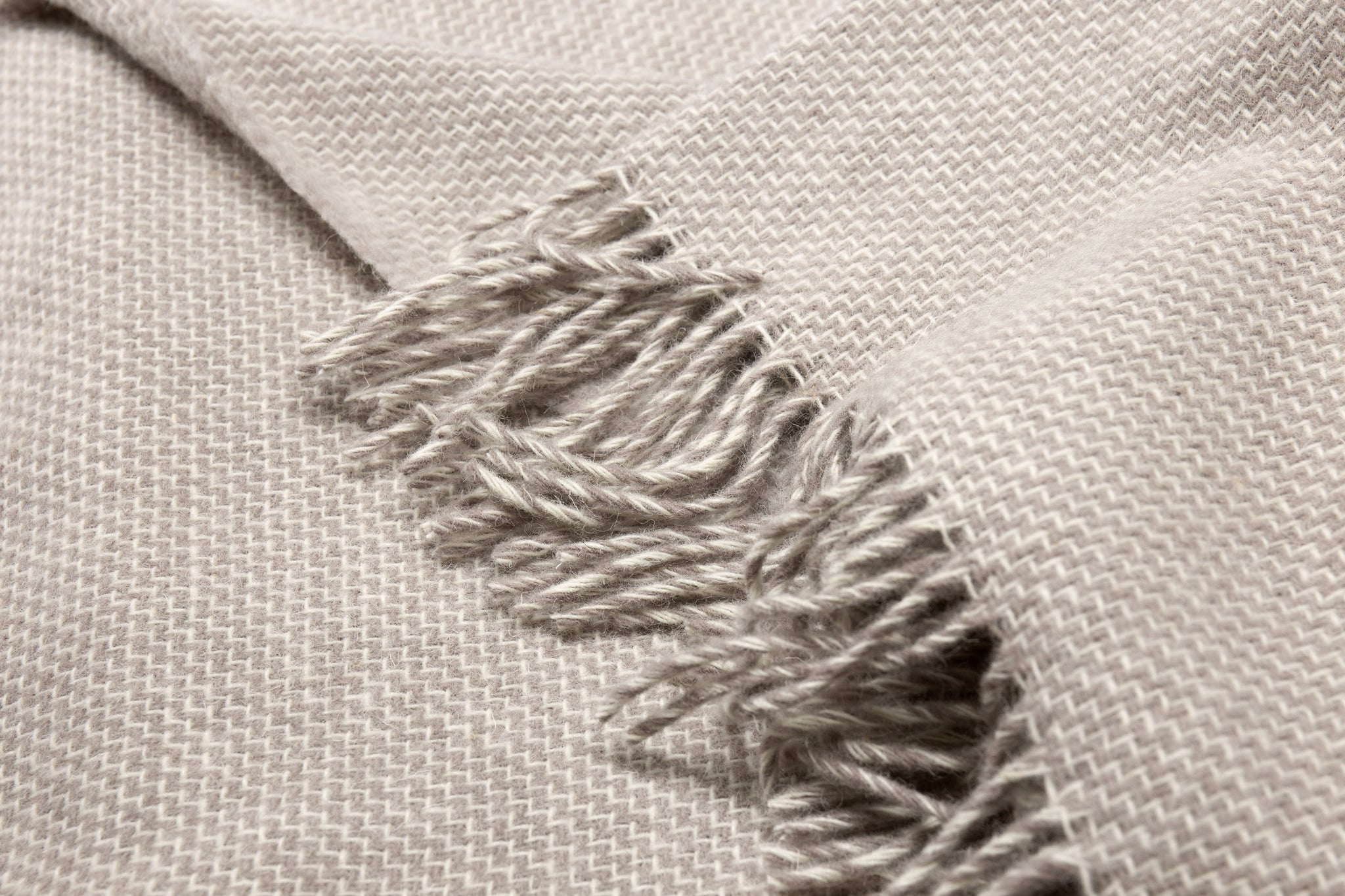 Cambridge wool throw with zigzag knit texture and heavy silver fringe detail
