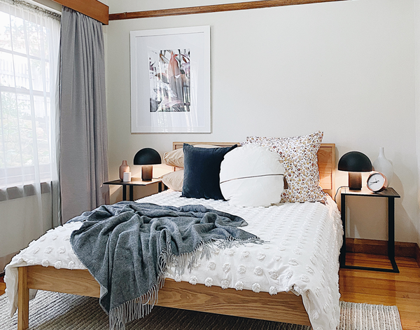 Charcoal throw blanket with fringed border, draped over bed
