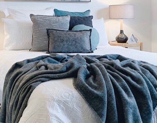 Dark gray throw blanket with soft woven texture and draped folds