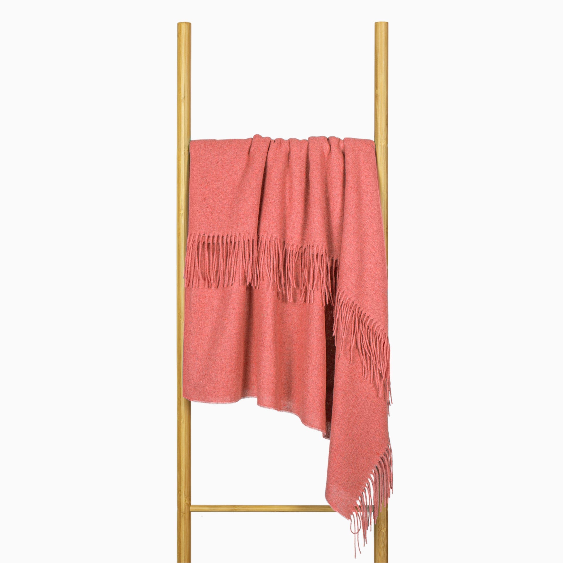 Peach wool-blend throw draped over frame with long fringe ends
