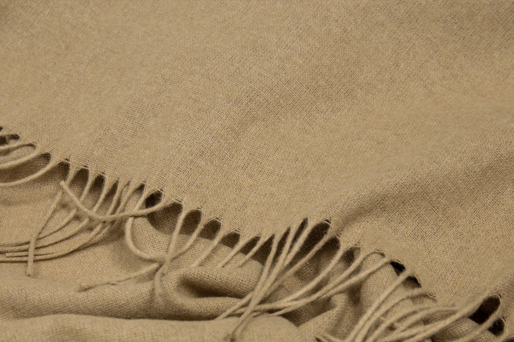 Camel throw close-up with woven texture and long fringe along the border.