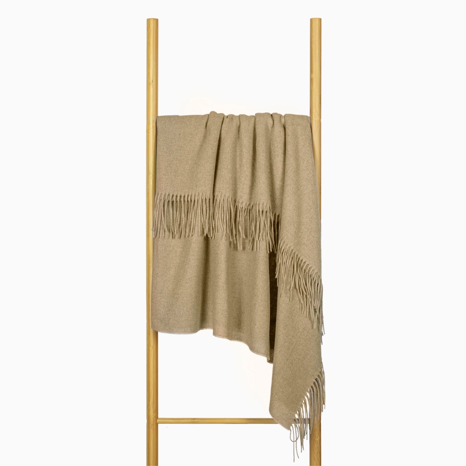 Camel wool throw draped over a wooden stand, showing fringe trim on corners.