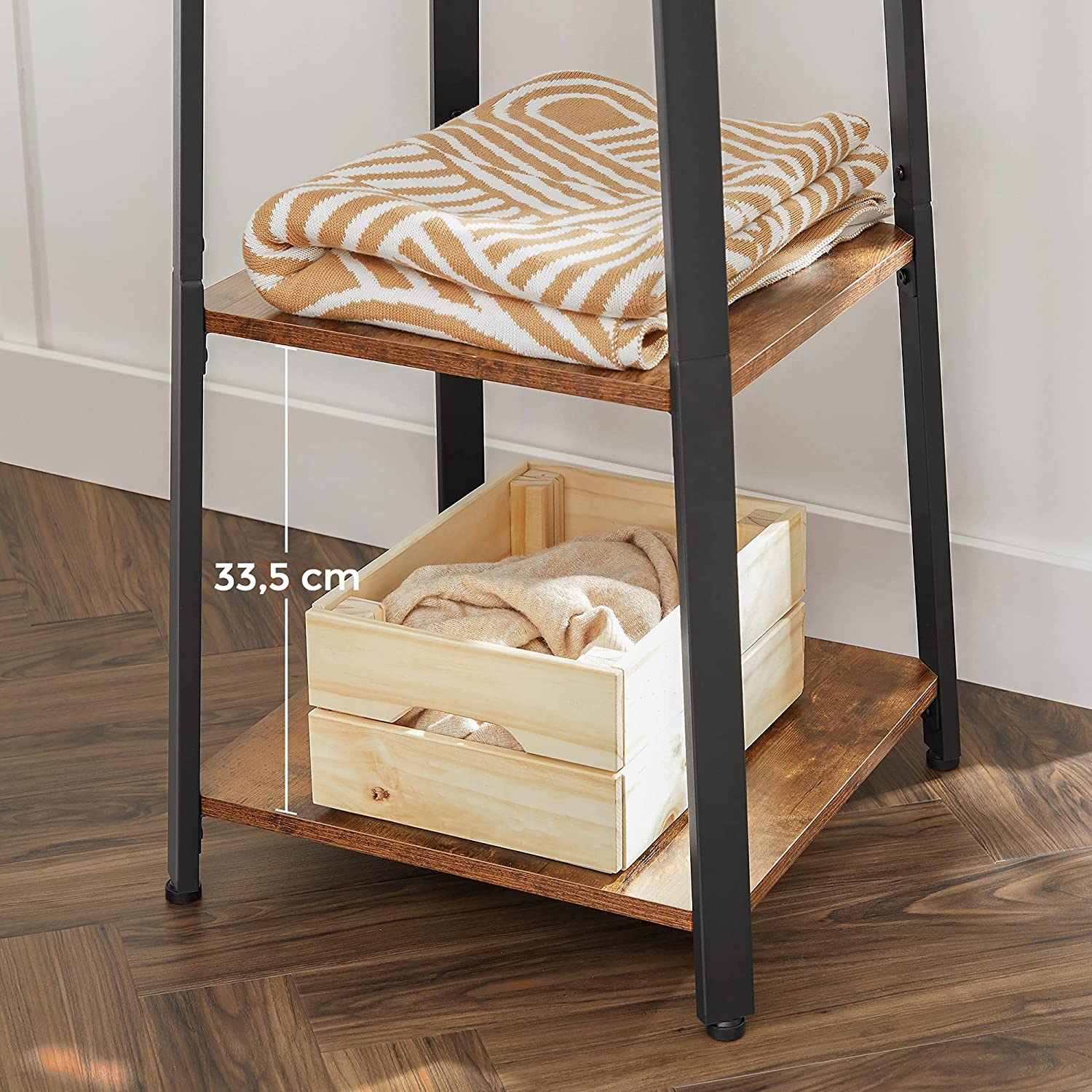 Coat rack with 3 shelves and hooks; top shelf holds a folded blanket.