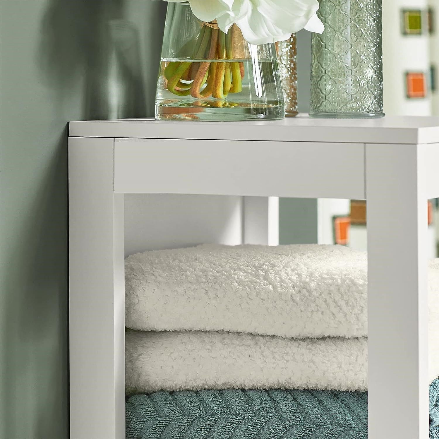 White cabinet with open shelf area and folded towels visible inside