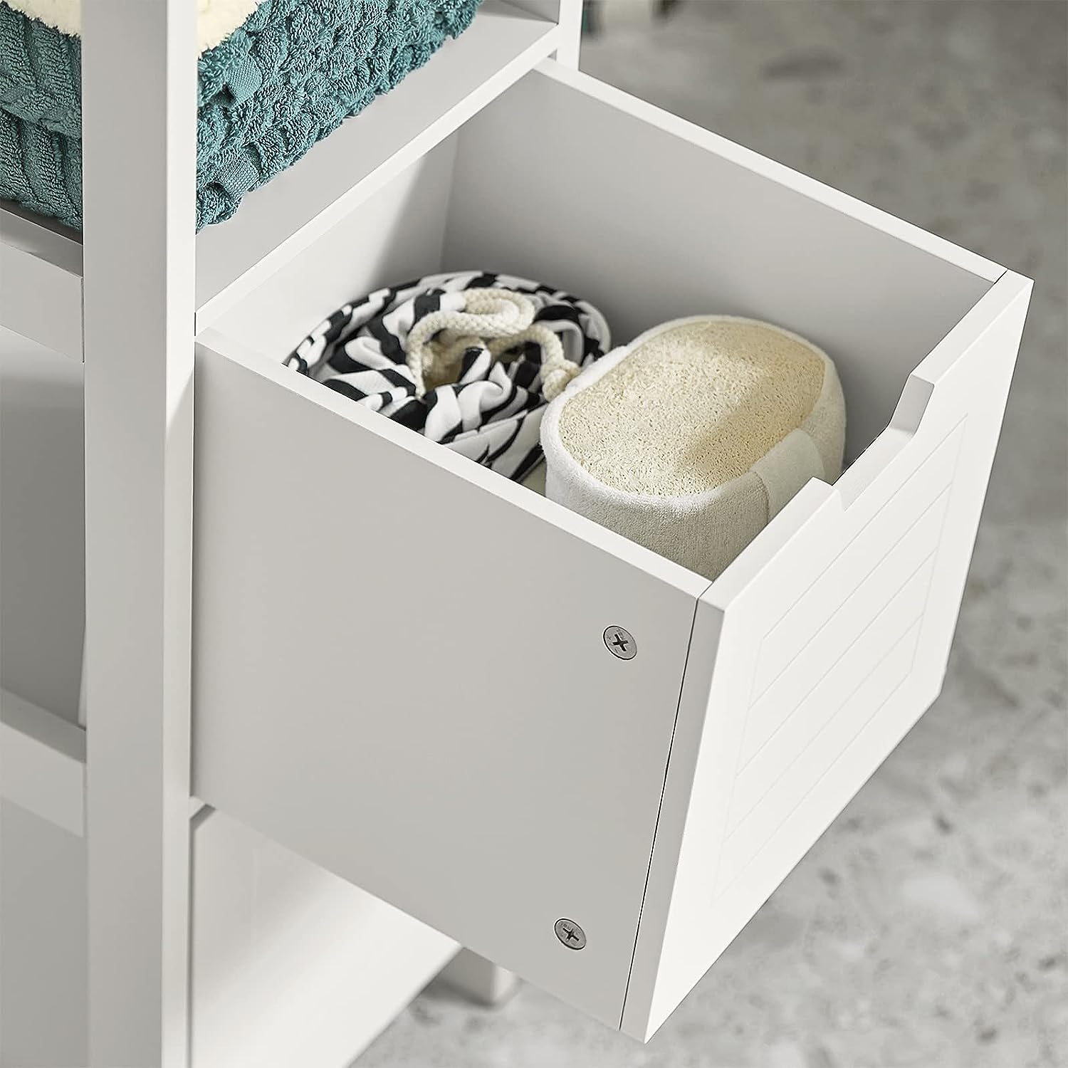 White cabinet drawer interior with divider panel and small items
