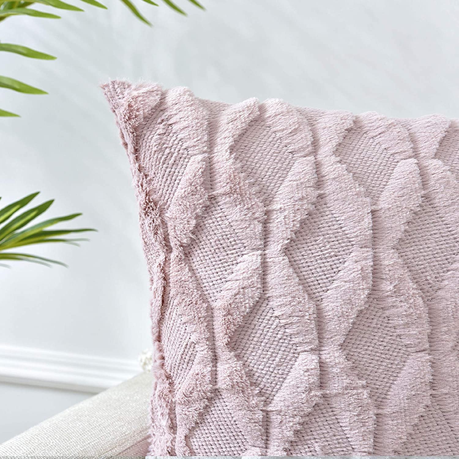 Pink diamond-knit pillow cover with fringed border on one corner