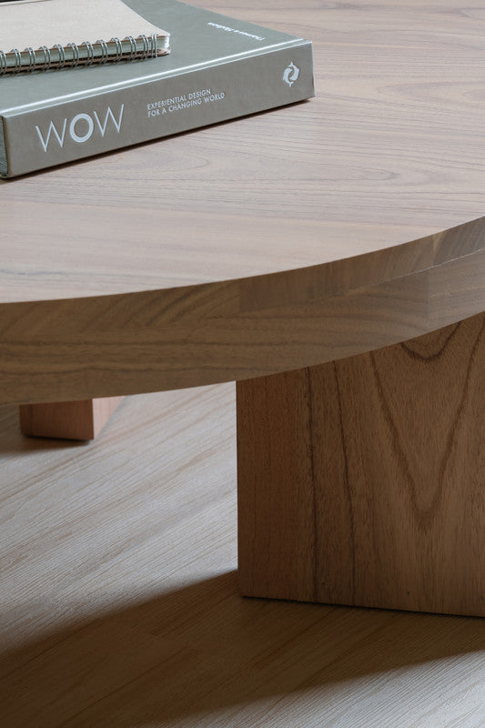 Natural wood round coffee table edge close-up with smooth grain and pedestal-style leg