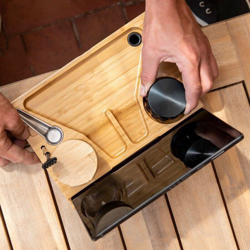 Hand lifting small cup from open wooden tray of a lockable storage chest