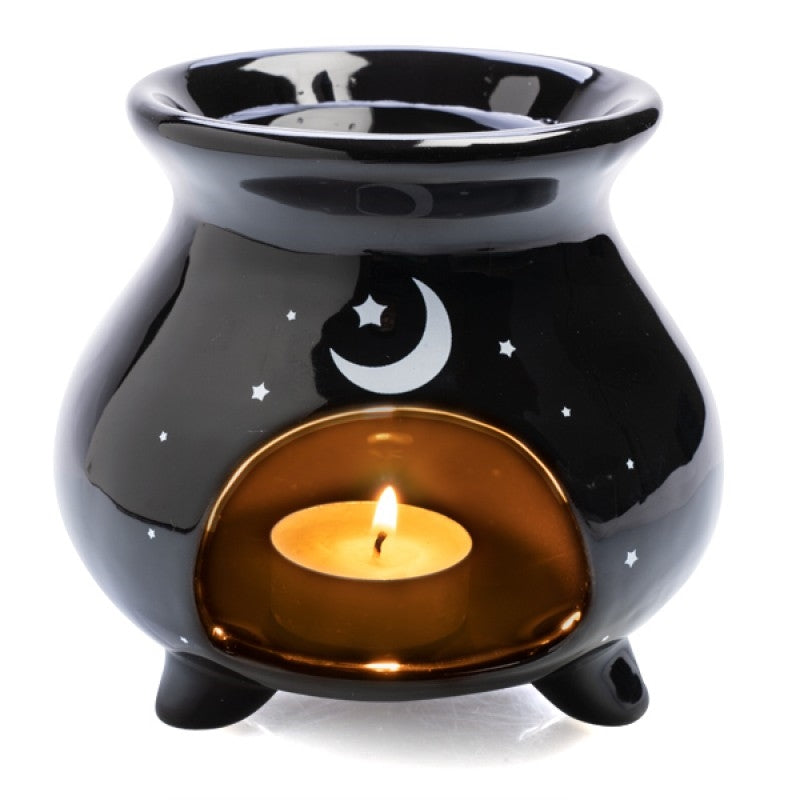 Witches' Brew cauldron oil burner with lit tealight, star and moon cutout design