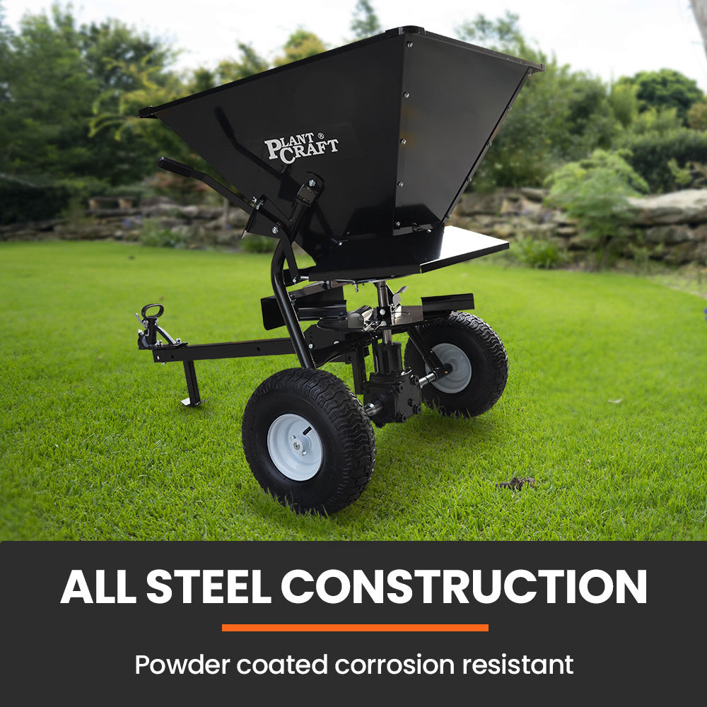 Tow-behind broadcast spreader with black steel hopper and four-wheel base