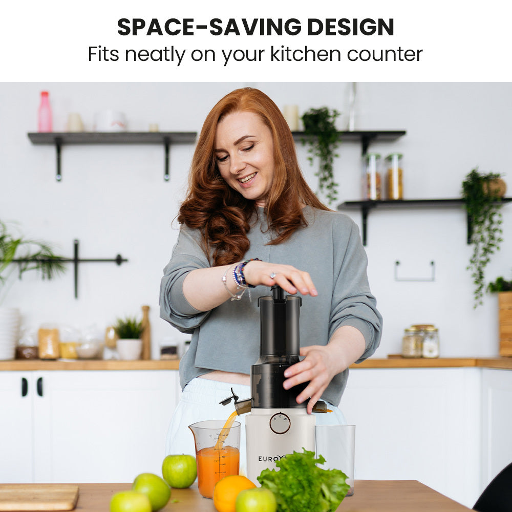 White cold press slow juicer with black top, operated on a kitchen counter