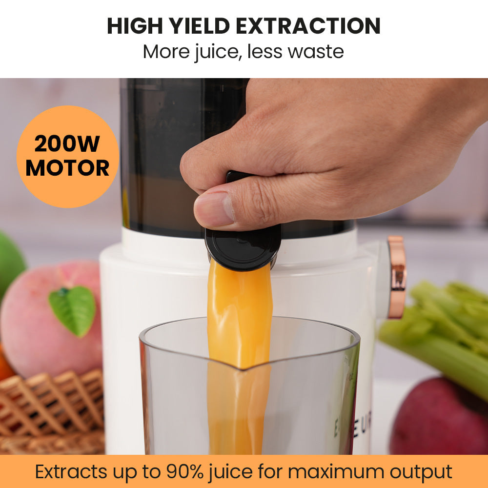 White cold press slow juicer with black hopper, hand pushing fruit into chute