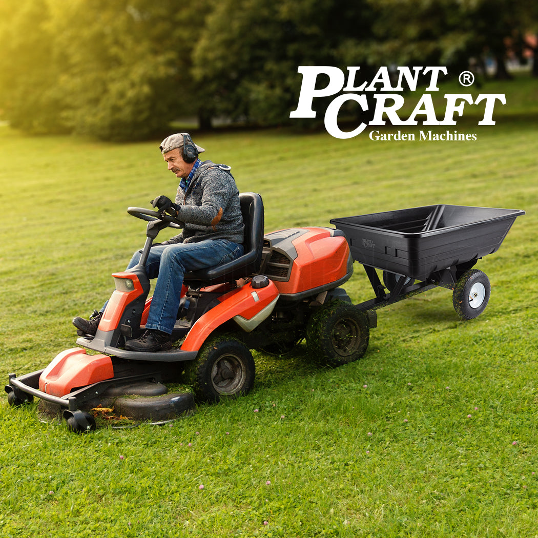 Black poly dump cart hitched to a ride-on lawn tractor
