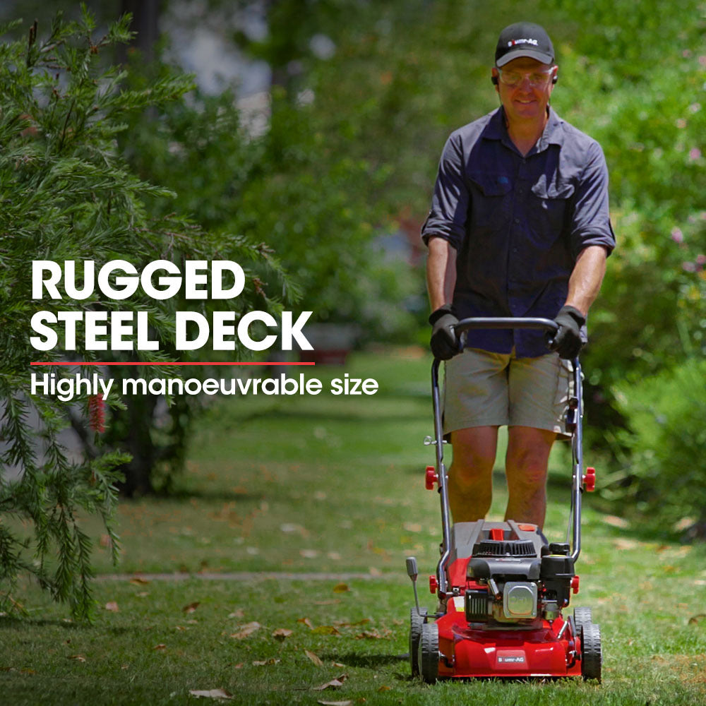Red petrol push lawn mower being pushed in a garden with visible wheels