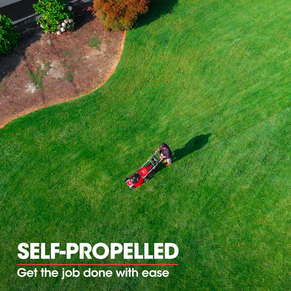 Red self-propelled lawn mower cutting a green lawn