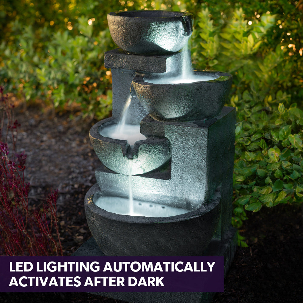 Charcoal four-bowl fountain with LED-lit water stream after dark