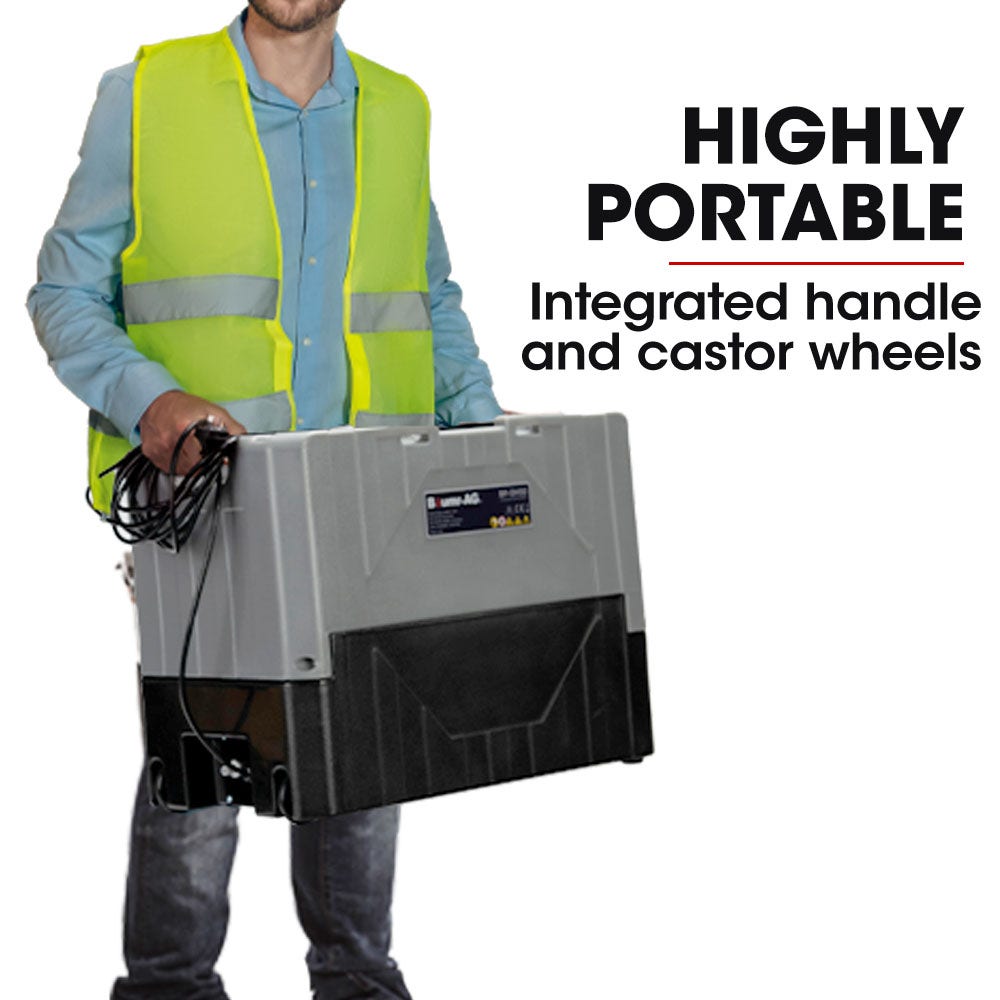 Portable air dehumidifier held by a person, with integrated handle and caster wheels