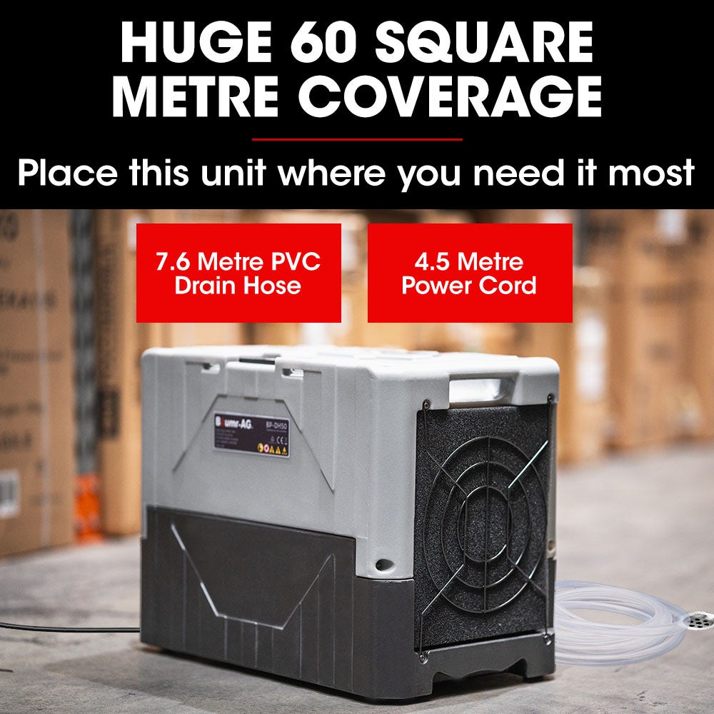 Portable air dehumidifier on floor with drain hose and power cord attached