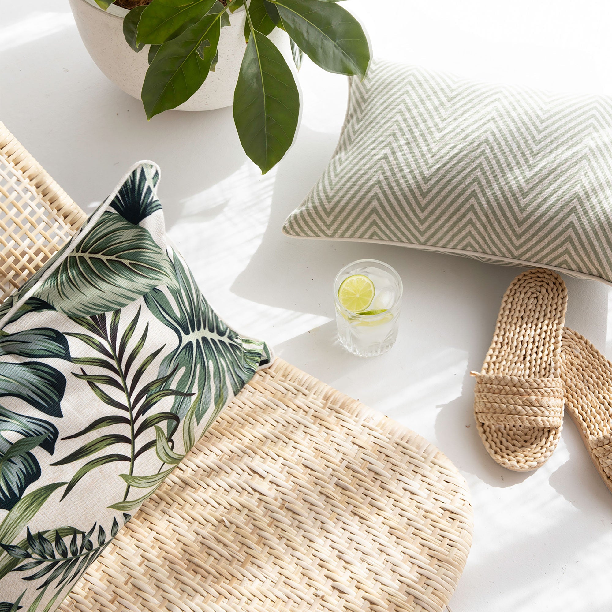 Tropical leaf cushion cover with green piping on a white base