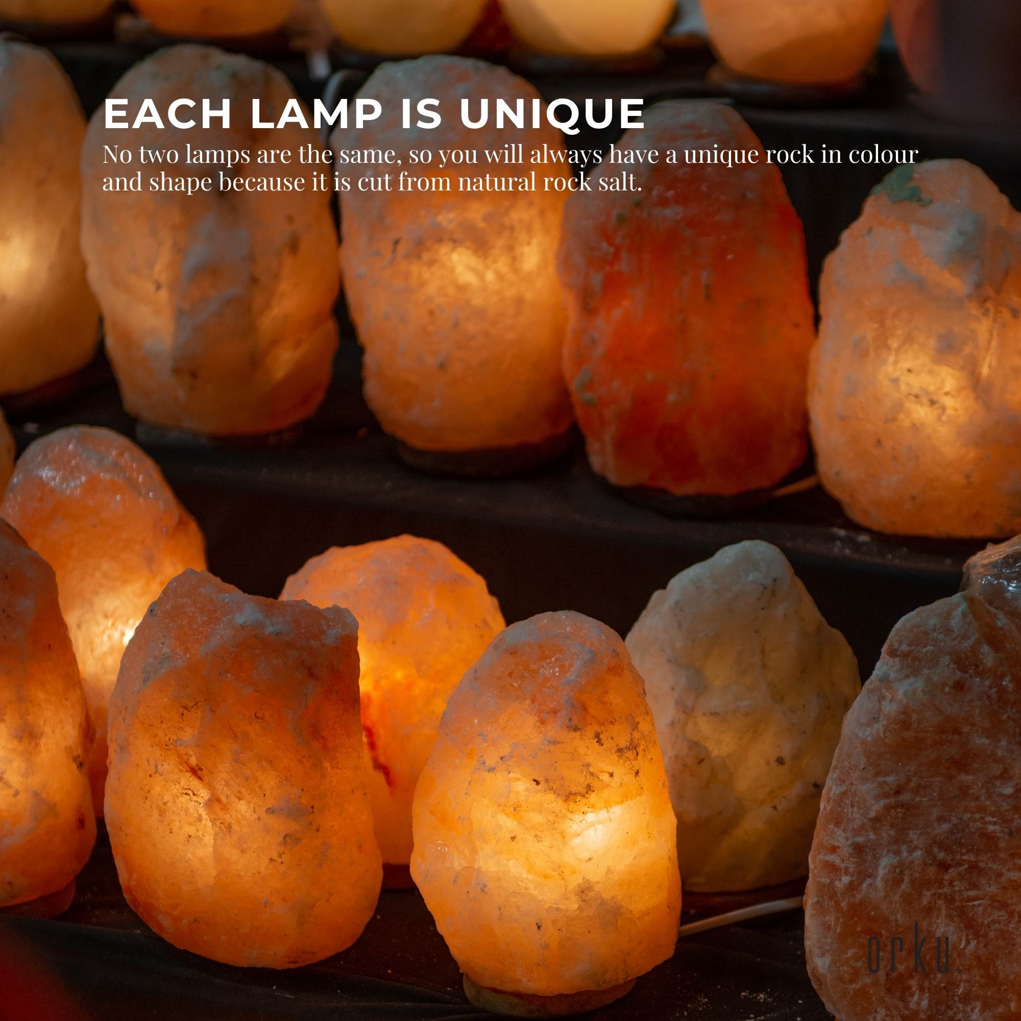 Glowing Himalayan salt lamps in varied rock shapes on a black tray