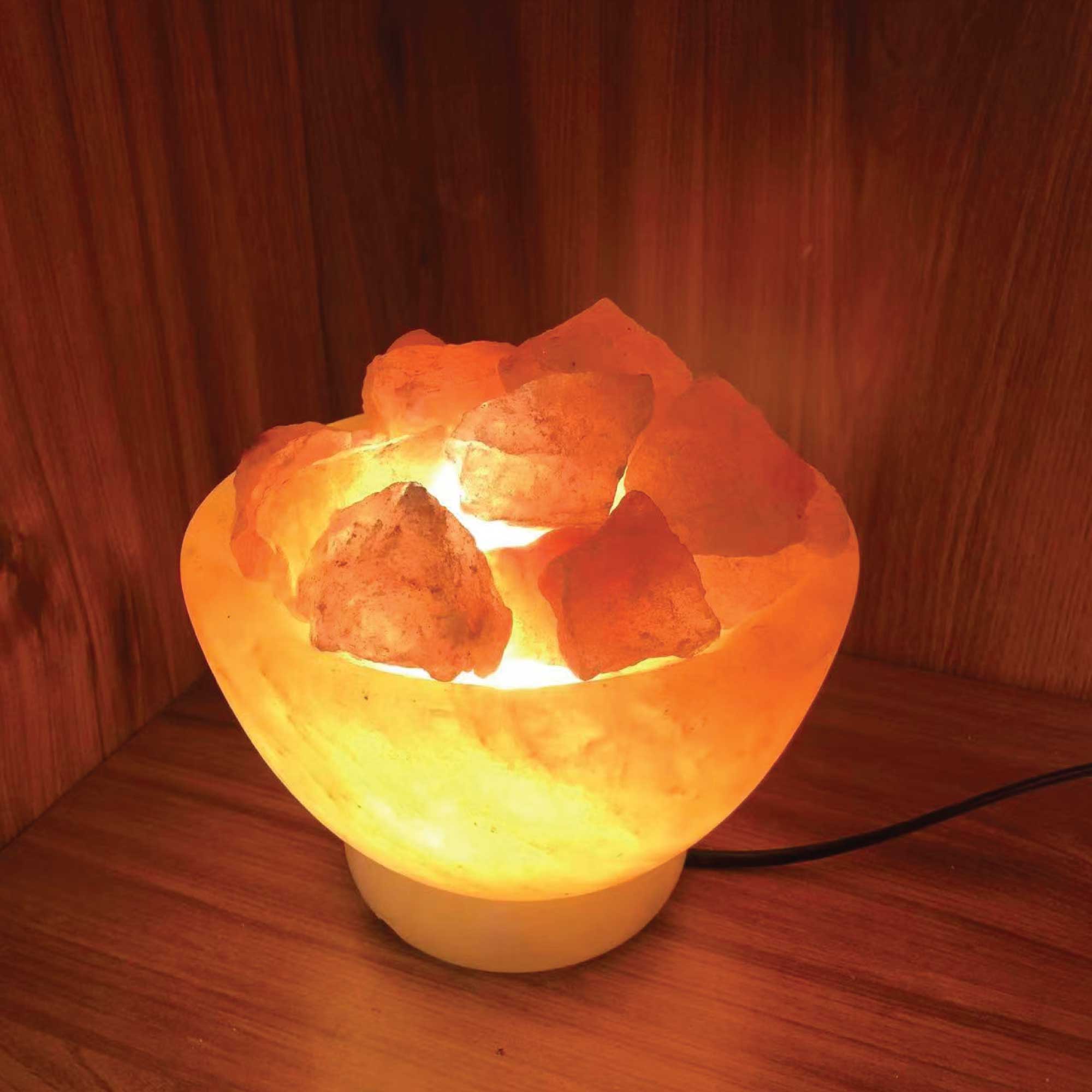 Himalayan pink salt fire bowl lamp, glowing warm light with carved rock crystal top