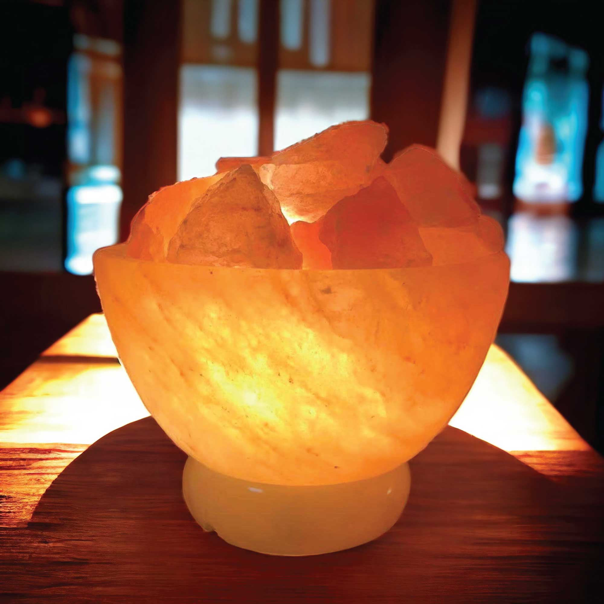 Himalayan pink salt fire bowl lamp with carved crystal rocks, illuminated warm glow