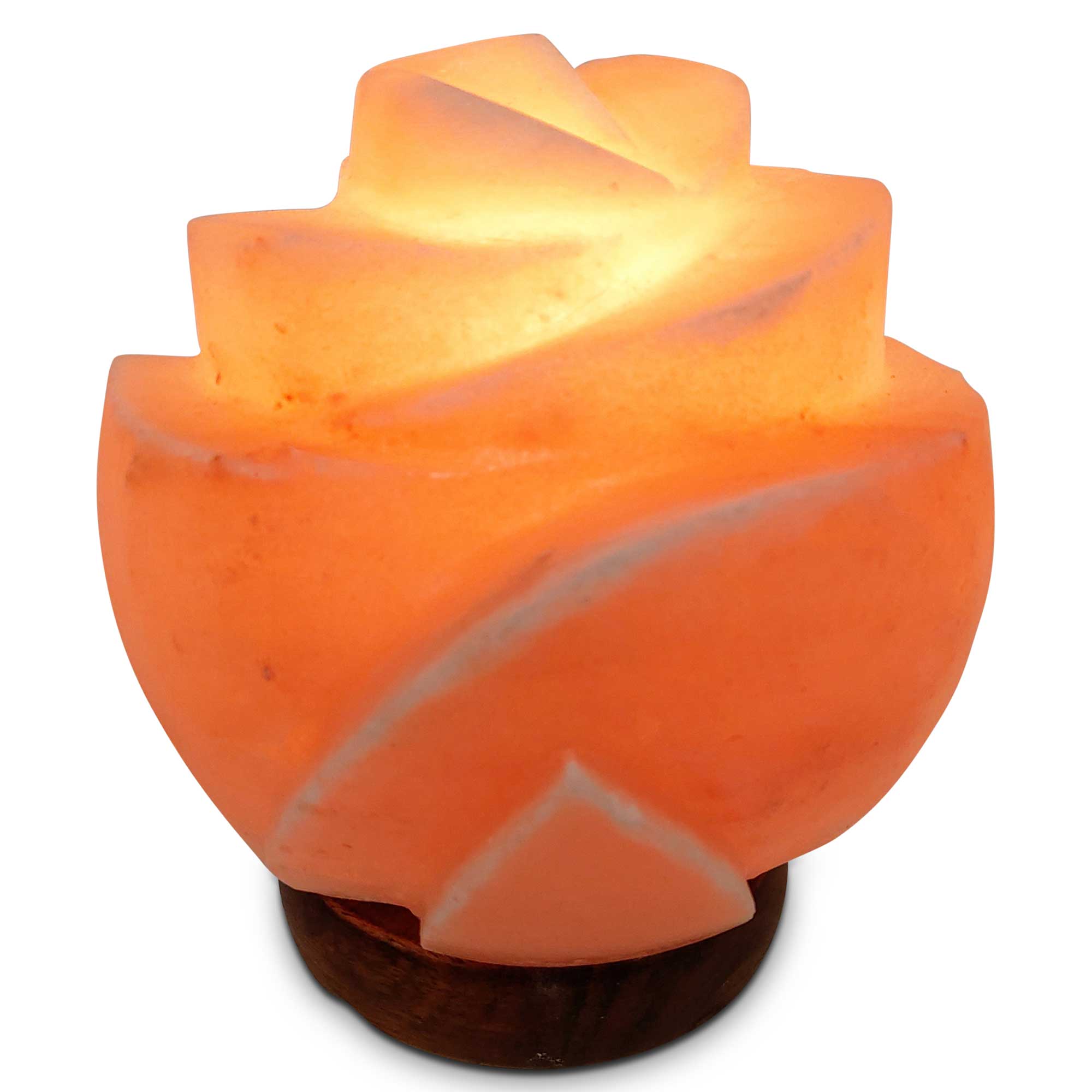Carved rose-colored salt lamp, flower shape on dark wooden base, lit warmly