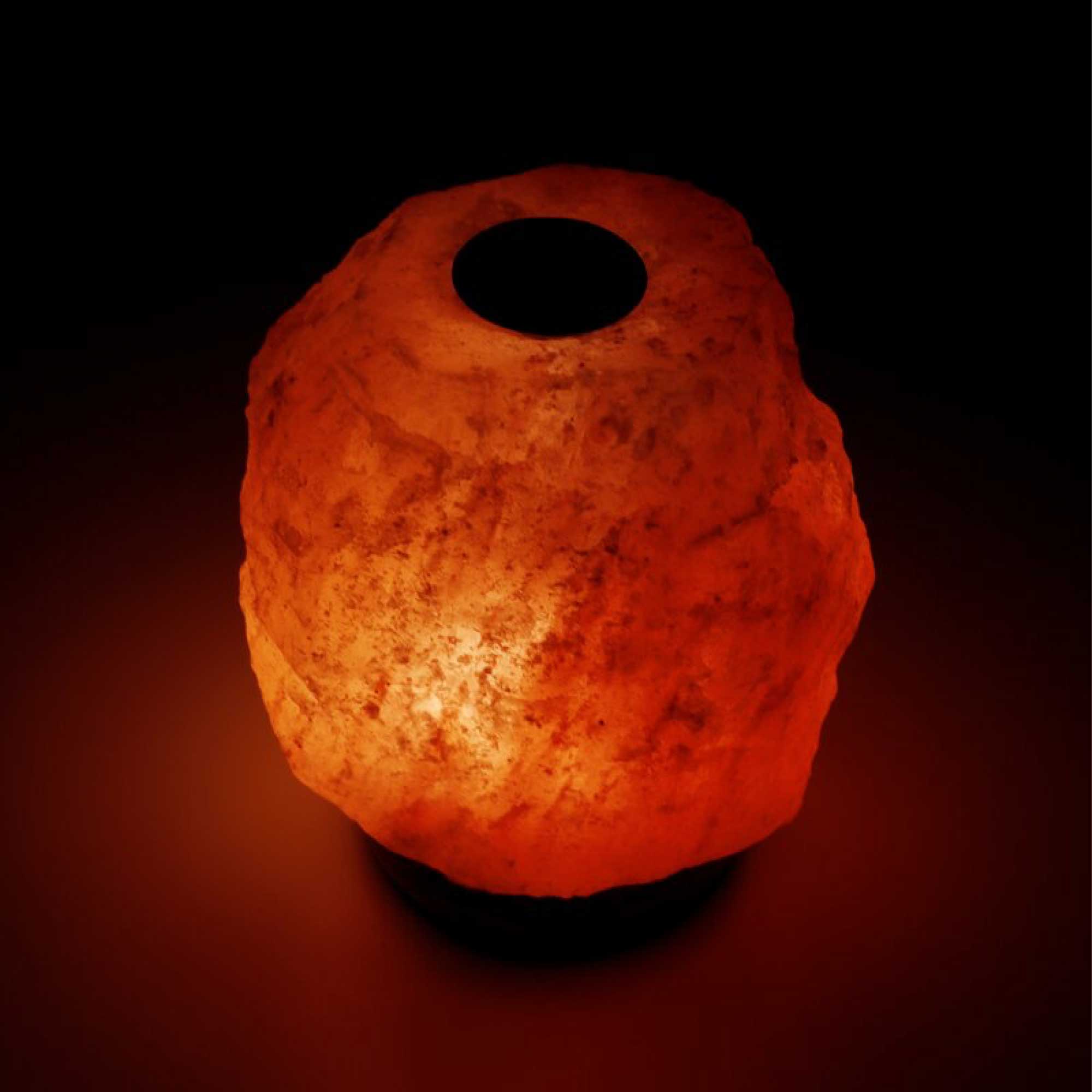 Himalayan salt diffuser lamp glowing orange with circular top opening and black stand base