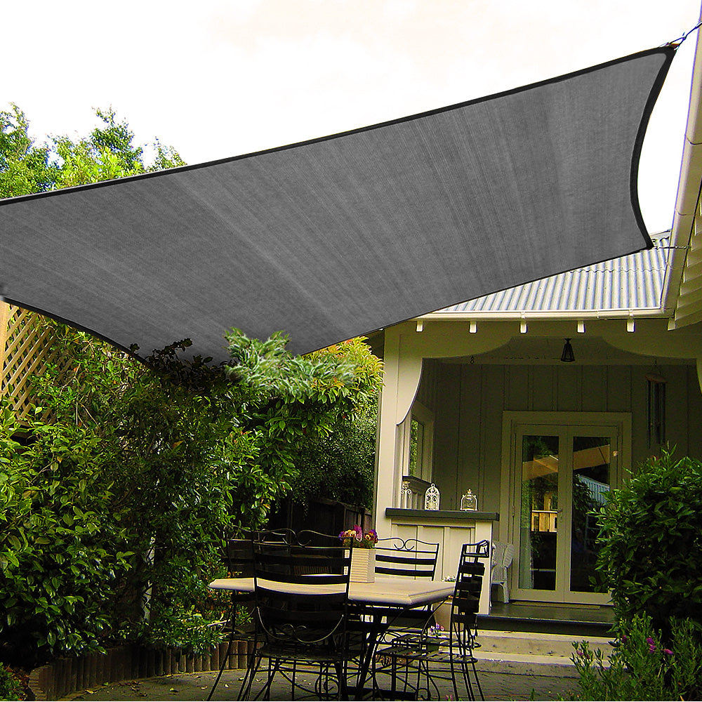 Grey rectangular shade sail spread over a patio, with black edge and corner ties