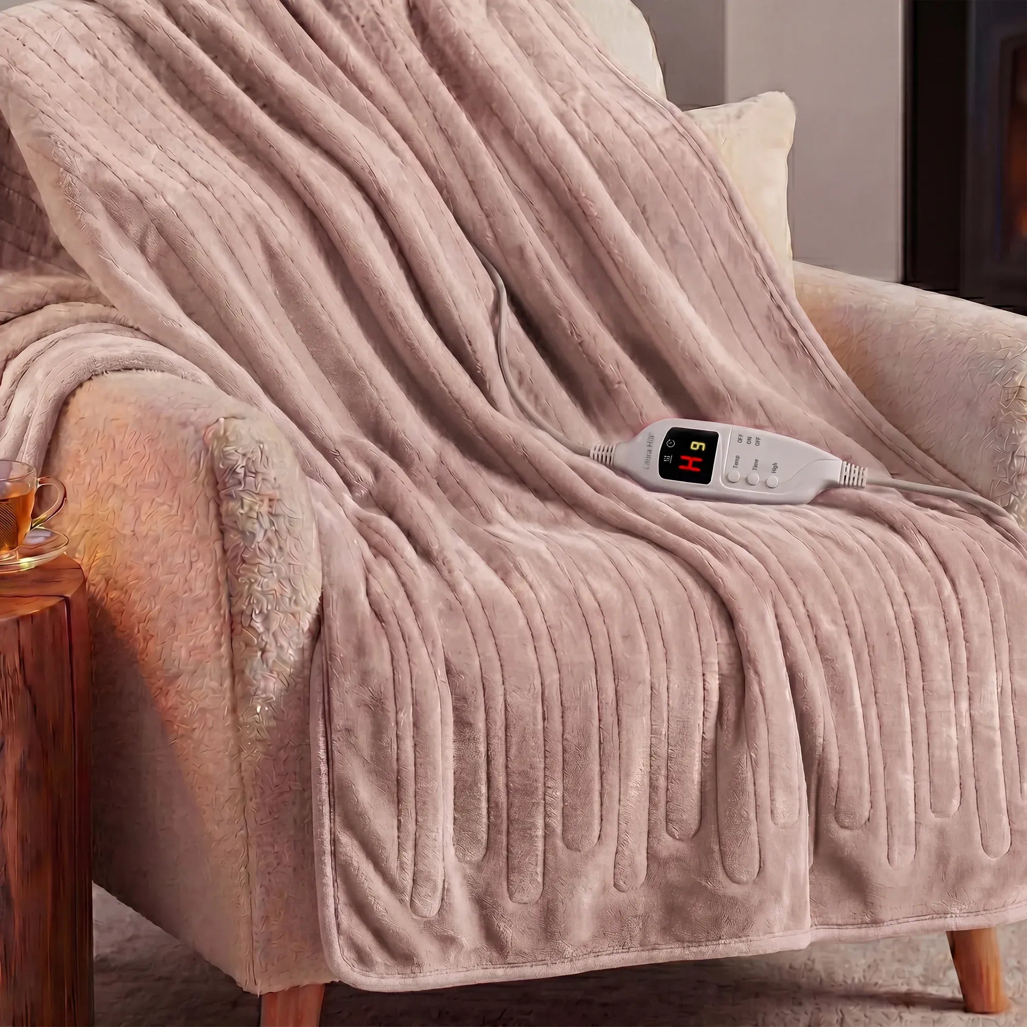 Coral pink coral fleece heated throw blanket draped over a seat with controller