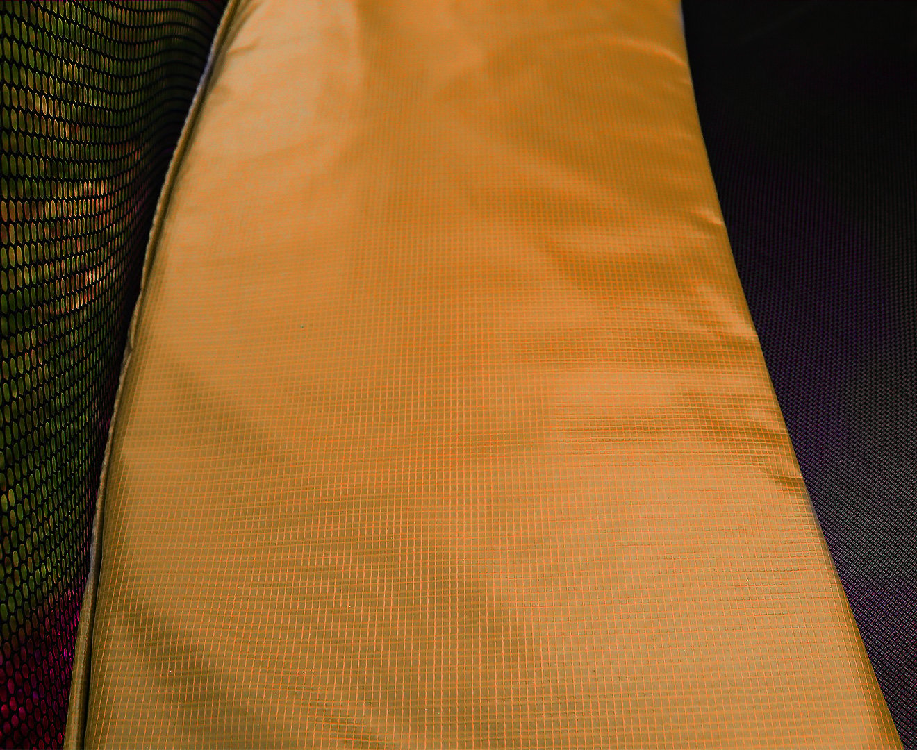 Orange trampoline pad panel with textured nylon mesh weave