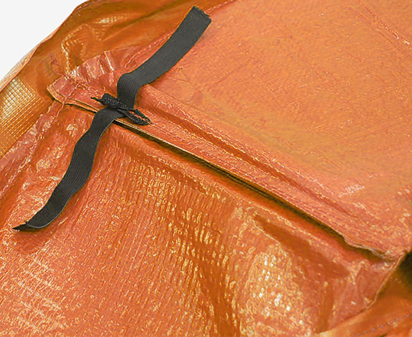 Orange trampoline pad corner with black tie straps on textured mesh