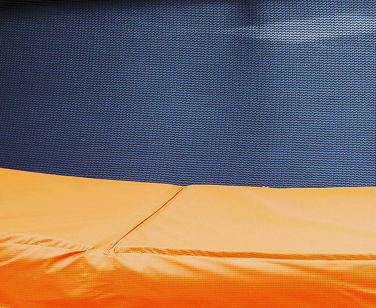 Trampoline pad with dark blue outer fabric and orange inner edge stitching