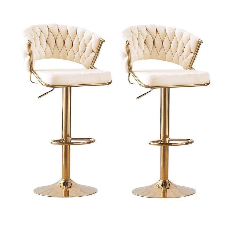 Pair of beige velvet bar stools with tufted back, padded seat, and round gold bases