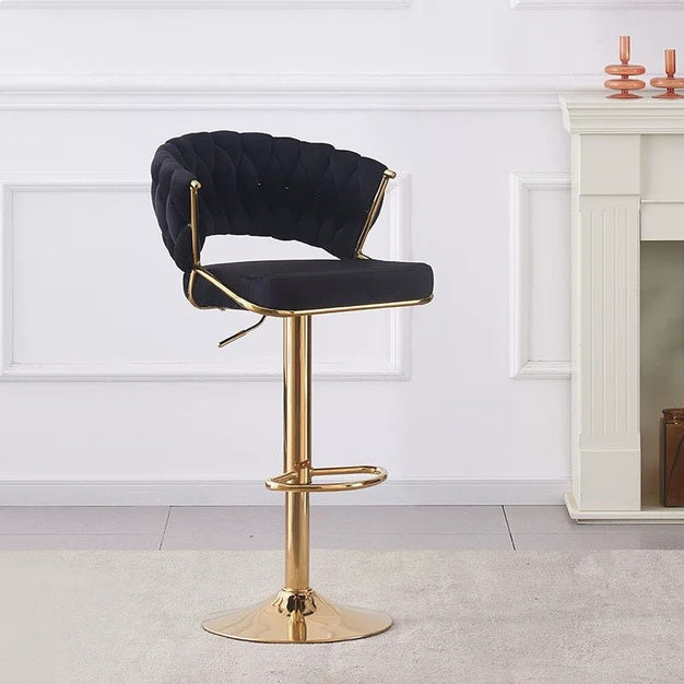 Black velvet barstool with curved padded back and gold pedestal base