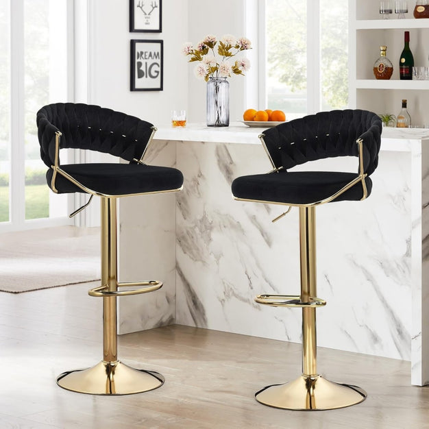 Set of two black velvet barstools with padded seats and gold pedestal bases