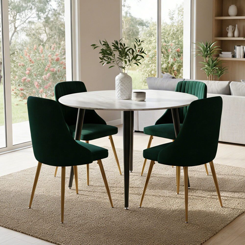 Round dining table with white top and 4 dark green velvet chairs with gold legs