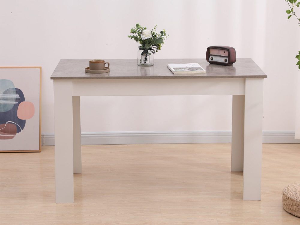 Rectangular dining table with grey top and white frame, shown with decor on the surface