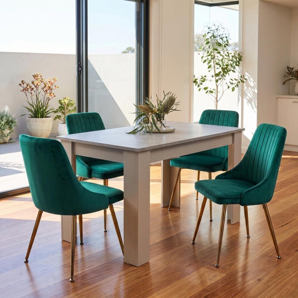 Rectangular grey dining table with four green velvet chairs around it