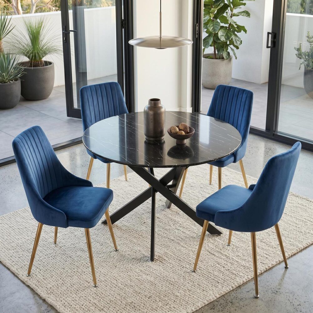 Round glass dining table with black X base and four blue upholstered chairs
